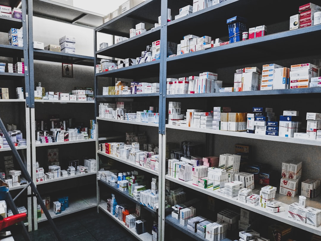 Pharmacy shelves organized with prescription medication boxes and healthcare products
